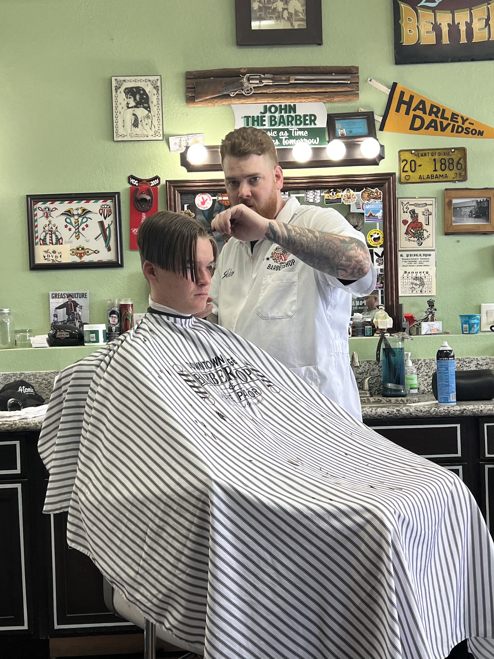 Barber John cutting a young client's hair in a vintage-decorated barbershop